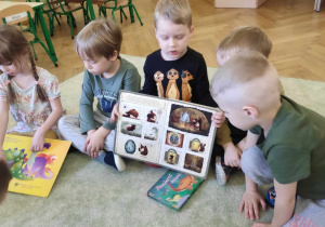 Dzieci prezentują swoje książki o dinozaurach.