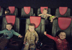 Dzieci czekają na rozpoczęcie seansu filmowego.