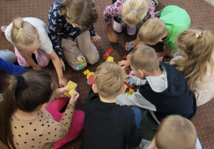 Dzieci podczas zabawy ruchowej- segregowanie figur według koloru.