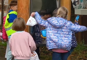 Dzieci bawią się przy lustrach zmieniających kształt.