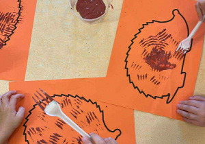 Dzieci malują kolce jeża z wykorzystaniem widelca.