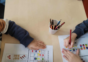 Dzieci wykonują kartę pracy z tematu kodowania.