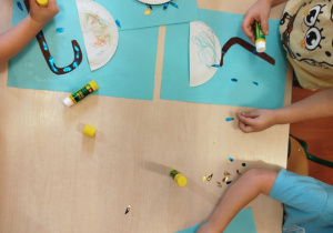 Dzieci wykonują pracę plastyczną- parasolki.