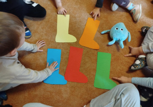 Dzieci rozpoznają i nazywają kolory papierowych kaloszy.