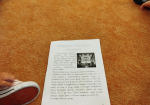 Dzieci słuchają opowiadania czytanego przez nauczyciela.