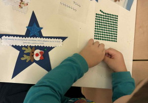 Julek wykonuje zaproszenie na uroczystość choinkową.