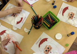 Zabawy z watę, doklejanie waty do pustego pola brody Świętego Mikołaja.