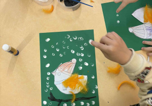 Malowanie białą farbą pracy plastycznej "Ptaki zimą".