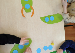 Dzieci tworzą swoje rakiety kosmiczne z kolorowego papieru.