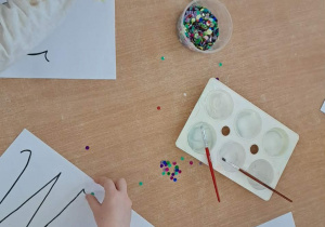 Ozdabianie cekinami literki "W".