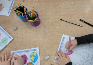 Dzieci wykonują kartę pracy: wypełnianie balonów wskazanym przez nitkę wzorem.