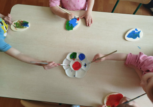 Dzieci malują styropianowe jajka.