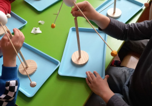 Dzieci wykonują balansujące jajka.