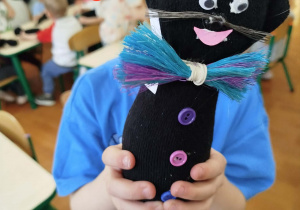 Dziecko prezentuje gotowego czarnego kotka.