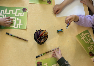 Przedszkolaki podczas wykonywania karty pracy - zaprowadź pieska do budy zbierając kości.